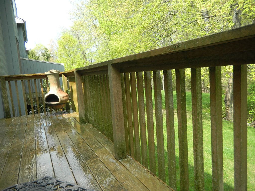 Closeup of pressure washing spray removing dirt and mildew from outdoor surface in Palm Beach County FL